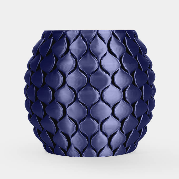 A glossy dark blue textured planter pot with a raised leaf-like pattern, centered on a light gray background.